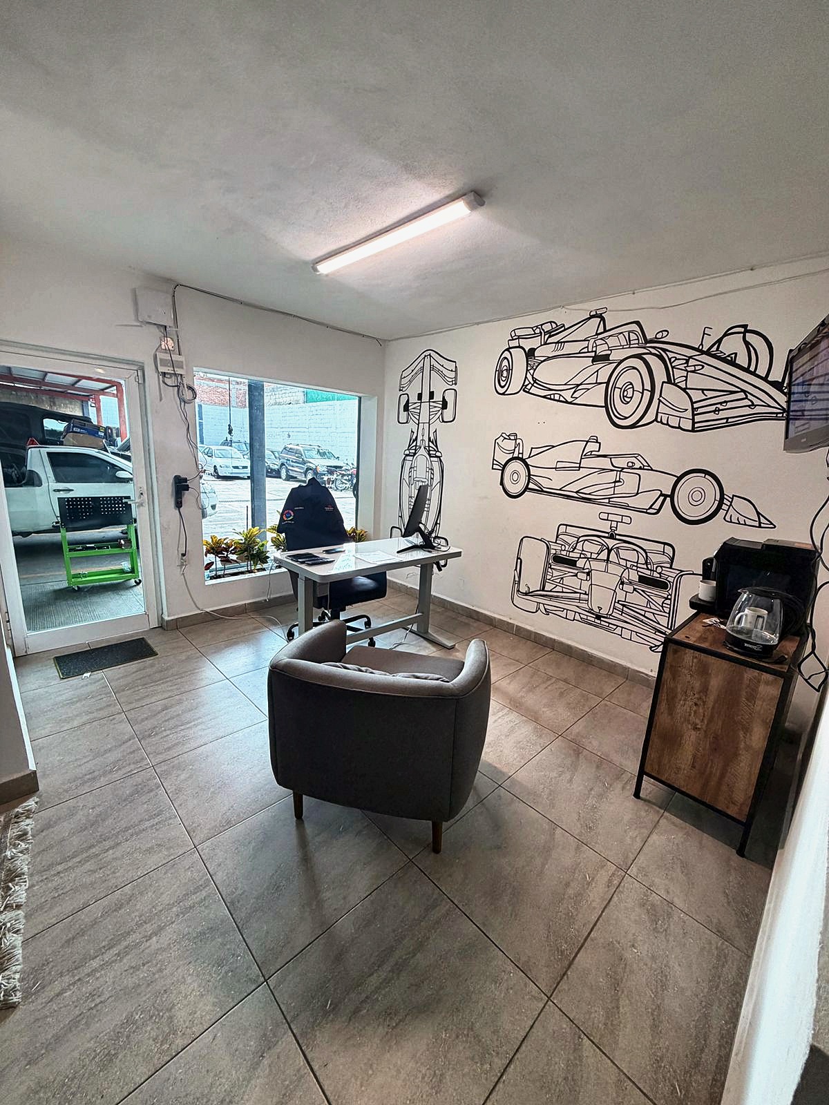 Sala de espera y recepción con mural de autos